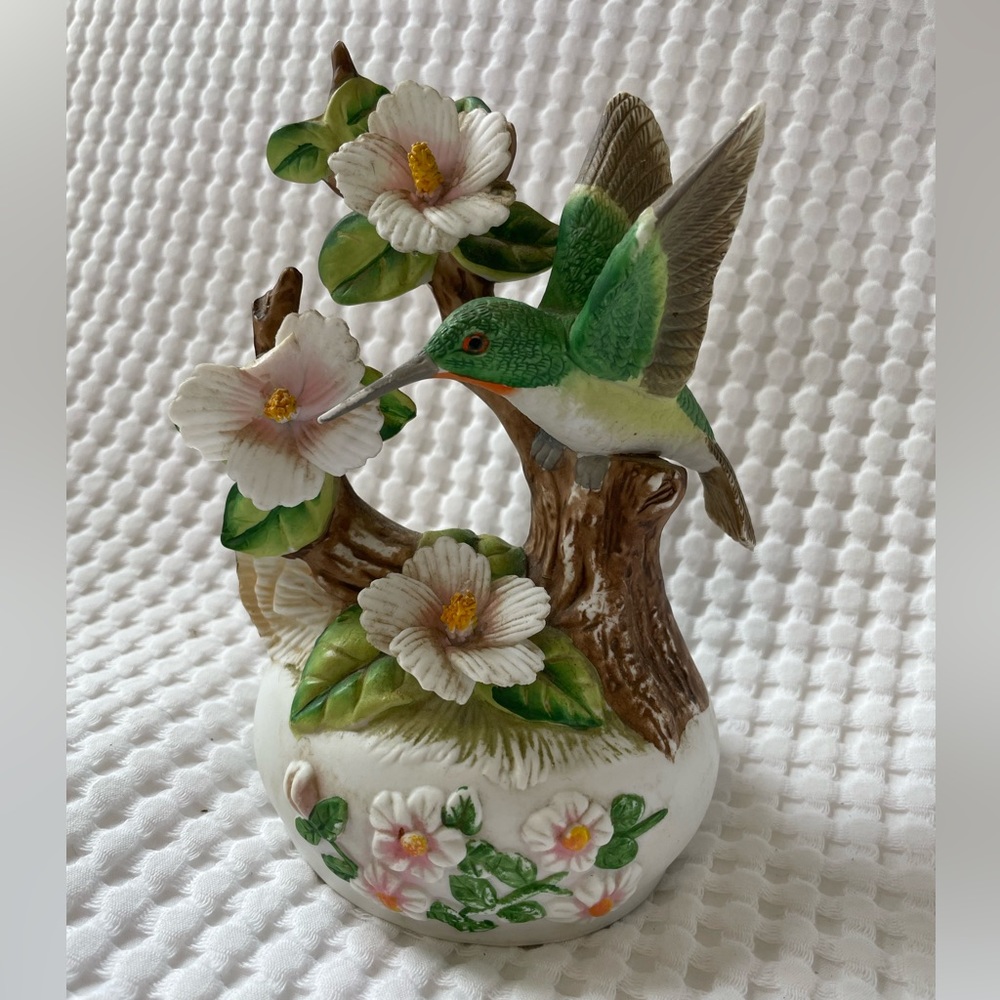 Ceramic hummingbird on flowers music box figurine.